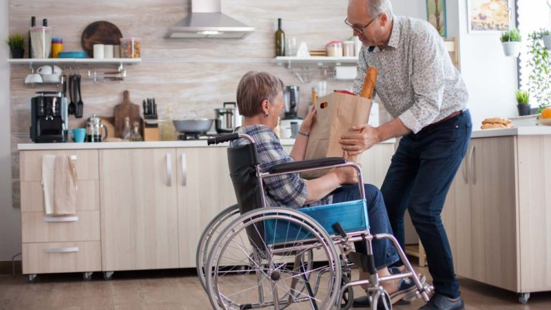 Elderly man helping woman with shopping